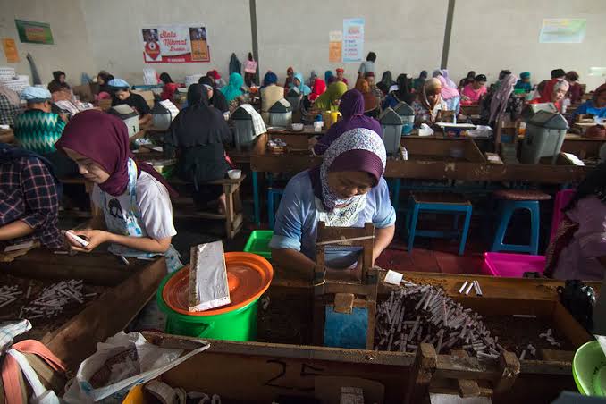 Caption : pekerja lagi merapikan rokok di pabrik.